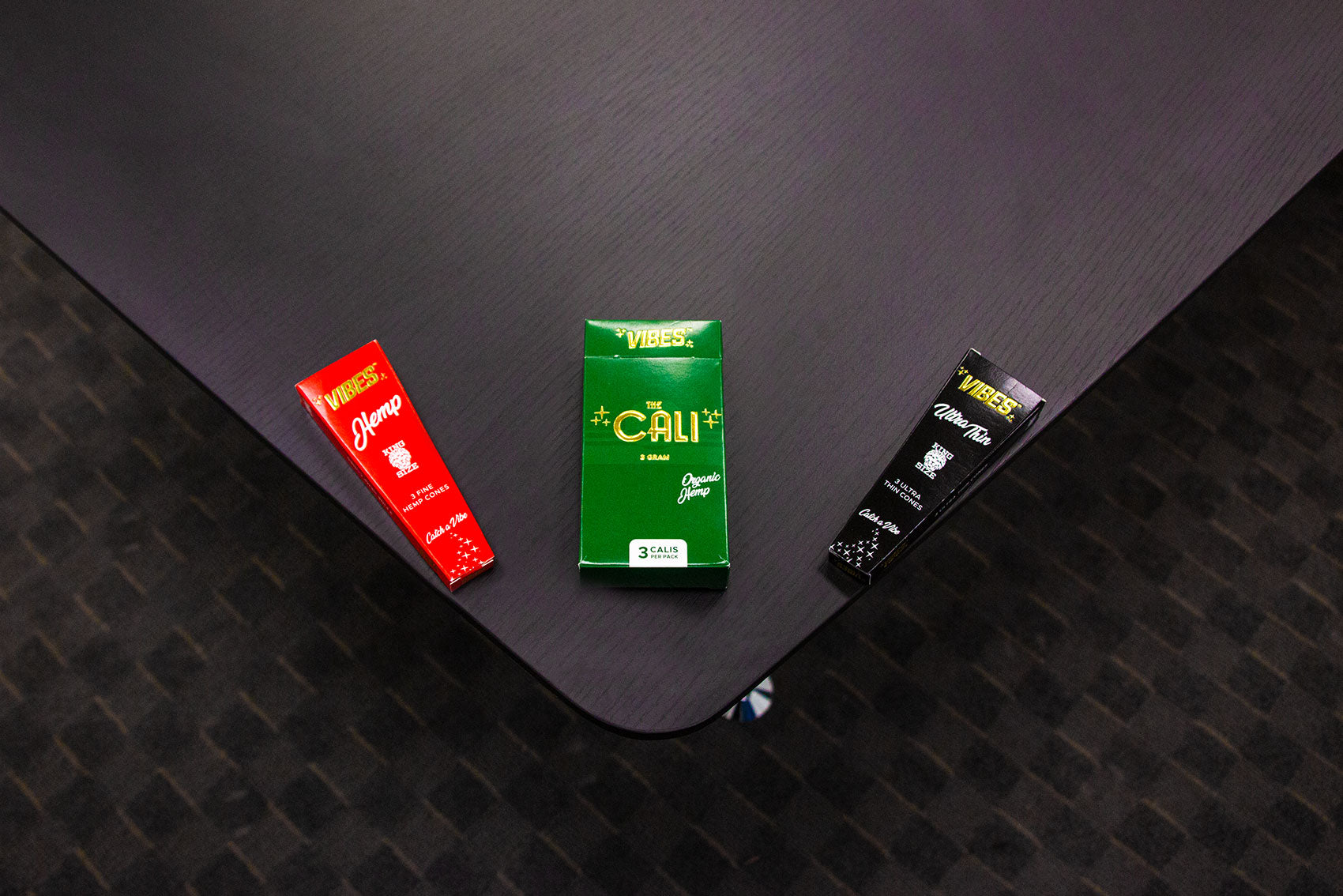 Wholesale Vibes Rolling Papers laying down on corner black office desk above view