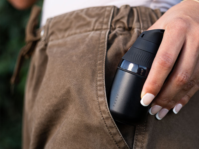 Person holding a Puffco Proxy Core in their pocket with a blurred background